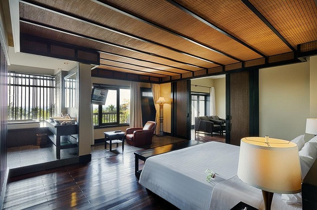 Phòng ngủ có ban công và quầy bar riêng biệt tại Princess d’An Nam Resort & Spa