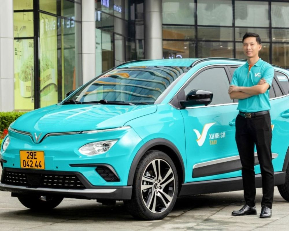 Một chiếc taxi điện Xanh SM màu xanh lá cây đang đỗ trên đường phố
