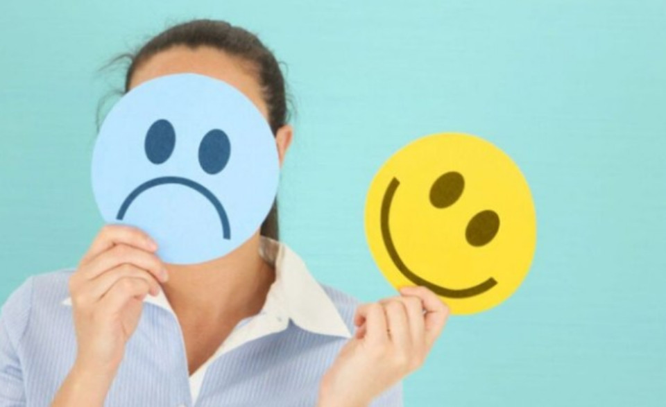 Một người phụ nữ trẻ với vẻ mặt căng thẳng, đặt tay lên trán, minh họa dấu hiệu một Cự Giải khó kiểm soát cảm xúc