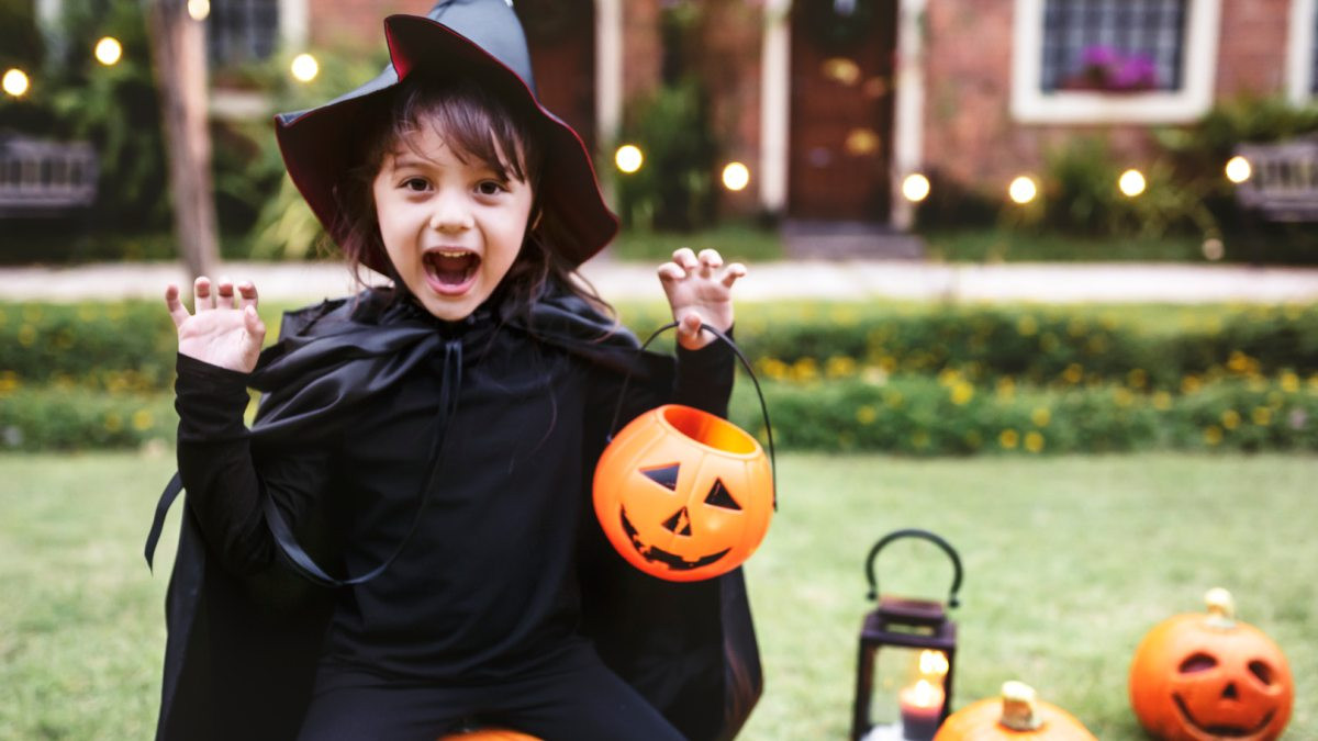 Bé gái với chiếc mũ phù thủy tự làm và trang phục hóa trang Halloween