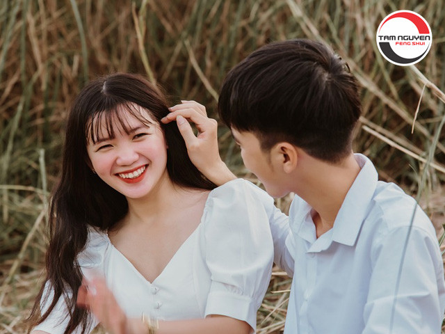 Một cặp đôi đang xem sách về phong thủy và bói tuổi vợ chồng