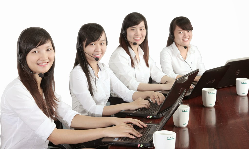 Nhân viên tổng đài đang đeo tai nghe và tập trung tư vấn khách hàng, thể hiện sự chuyên nghiệp và tận tâm