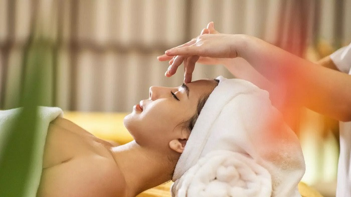 Kỹ thuật viên đang massage vùng cổ vai gáy kết hợp trị liệu