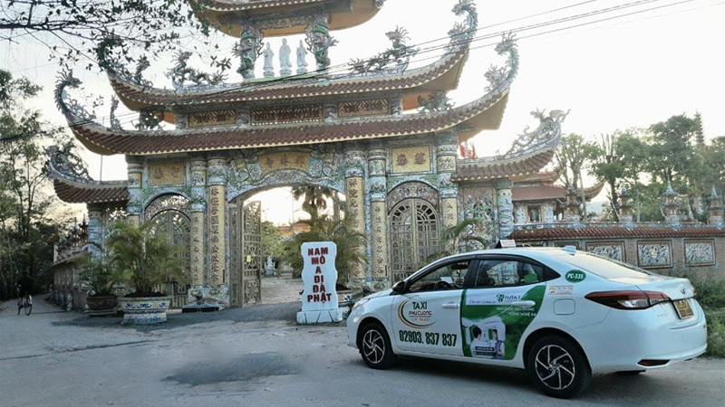Một chiếc taxi Phú Cường màu trắng đỗ ven đường tại Cà Mau, sẵn sàng phục vụ khách hàng với giá cả phải chăng