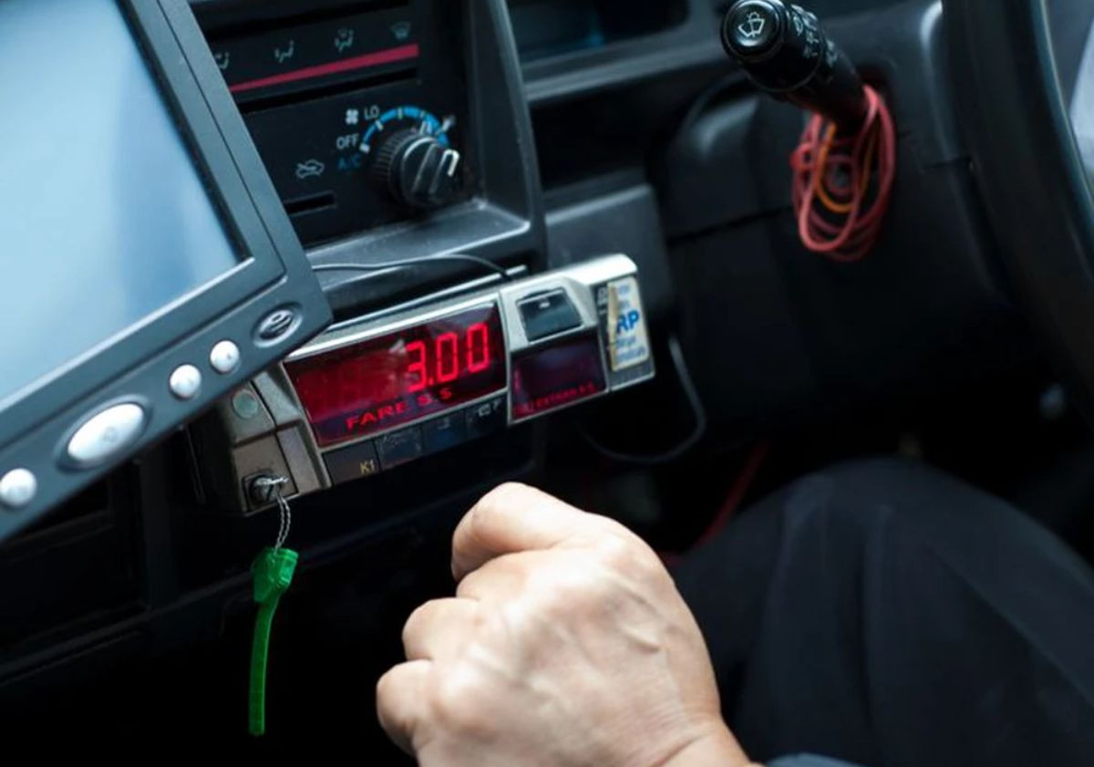 Hành khách đang kiểm tra đồng hồ tính cước trên xe taxi để đảm bảo minh bạch